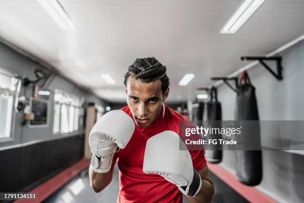 retrato de un joven practicando boxeo o muay thai en el gimnasio - muay thai fotografías e imágenes de stock