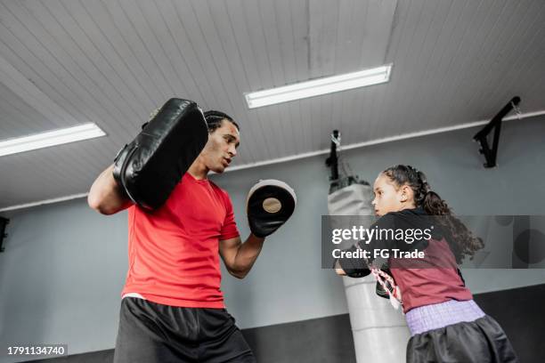 niña practicando boxeo o muay thai con instructor en el gimnasio - muay thai fotografías e imágenes de stock