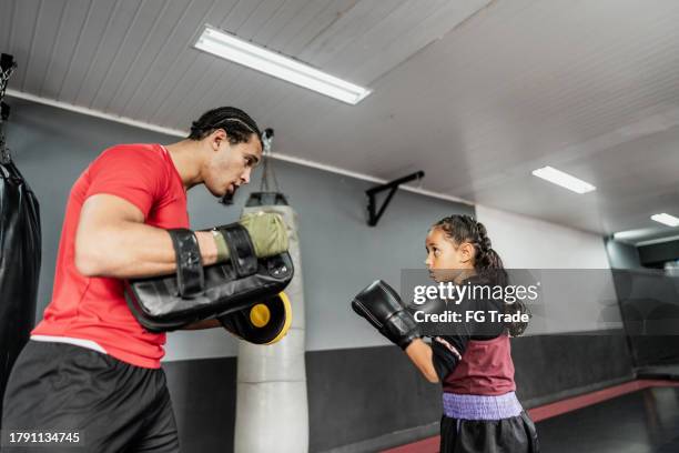 child girl practicing boxing or muay thai with instructor at gym - sport determination stock pictures, royalty-free photos & images