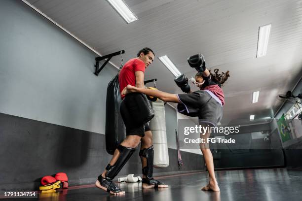 niña practicando boxeo o muay thai con instructor en el gimnasio - muay thai fotografías e imágenes de stock