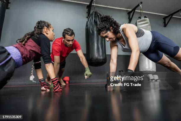 el equipo de boxeo haciendo flexión de brazos en el gimnasio - mixed boxing fotografías e imágenes de stock
