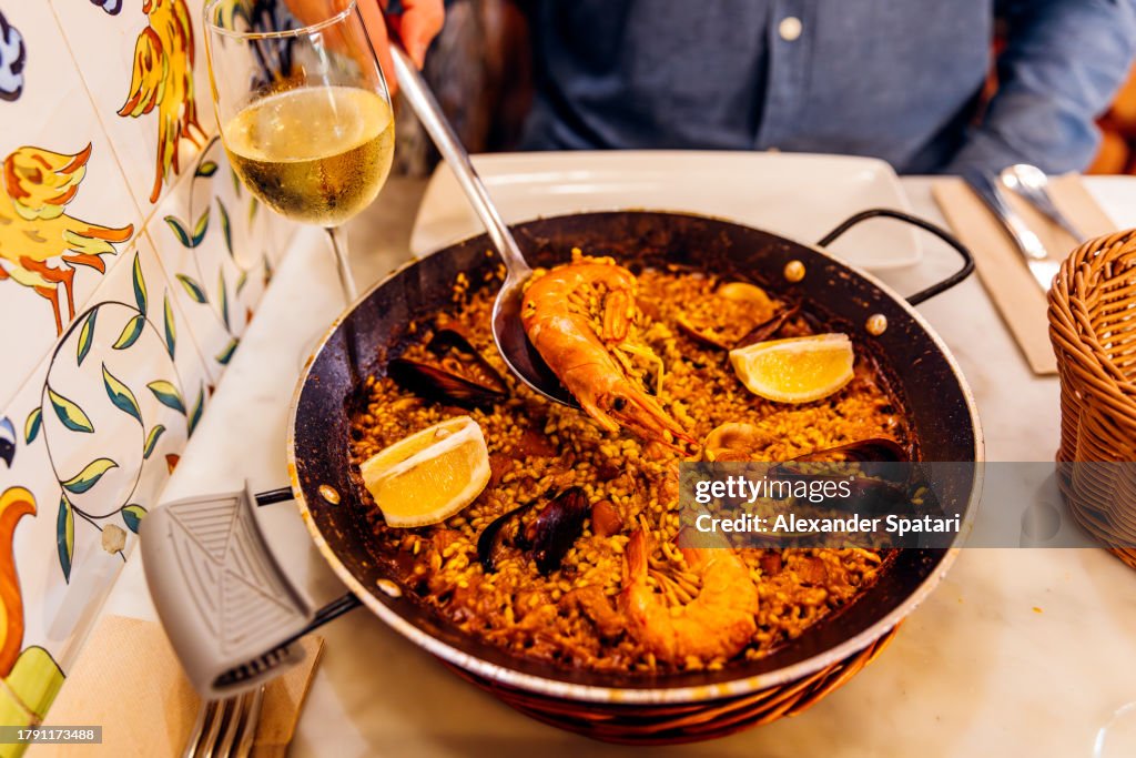Man eating seafood paella at Spanish restaurant, Barcelona, Spain