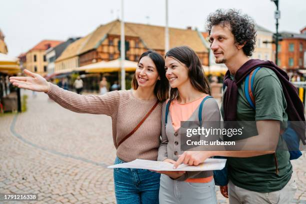 three young friends looking up directions on the map in malmo in sweden - stockholm map stock pictures, royalty-free photos & images