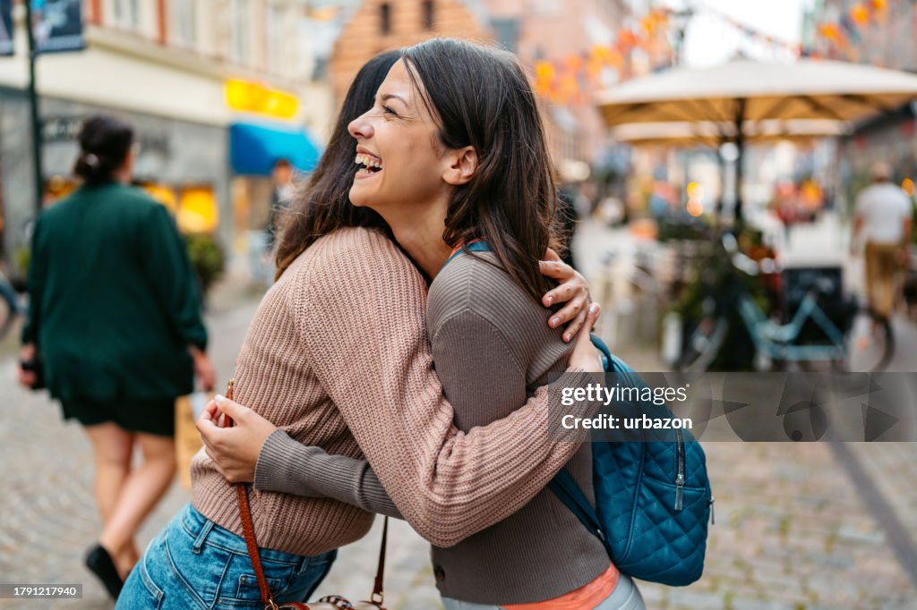 Two Female Friends Embracing On The Stortorget Square In Malmo In Sweden
