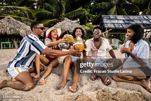 Young friends making a celebratory toast at the beach Young friends making a celebratory toast at the beach