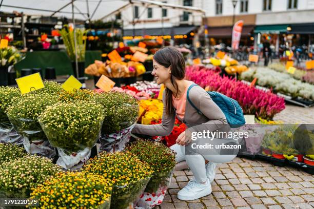 young woman shopping for flowers on the stortorget square in malmo in sweden - malmo stock pictures, royalty-free photos & images