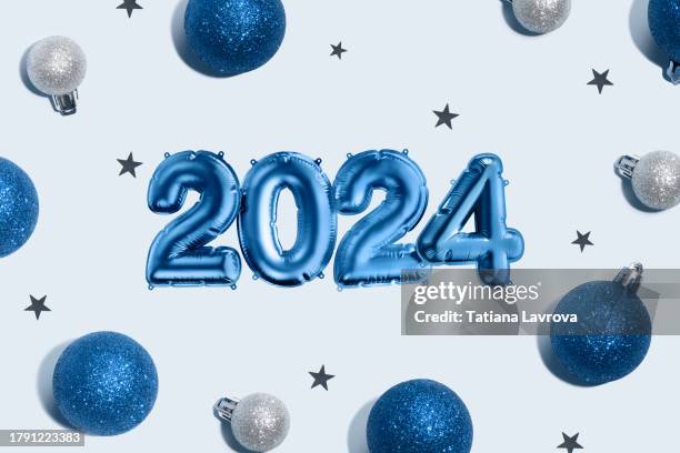 festive blue background with foil balloon numbers 2024, baubles and glitter. 3d rendered image and photo collage. christmas decoration wallpaper. seasonal winter composition - balloon stock pictures, royalty-free photos & images