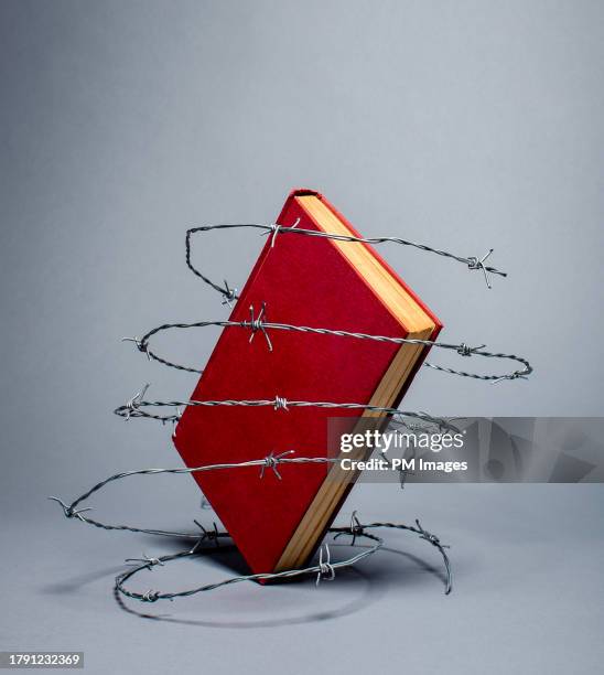 banned book in barbed wire - protective barrier stock pictures, royalty-free photos & images