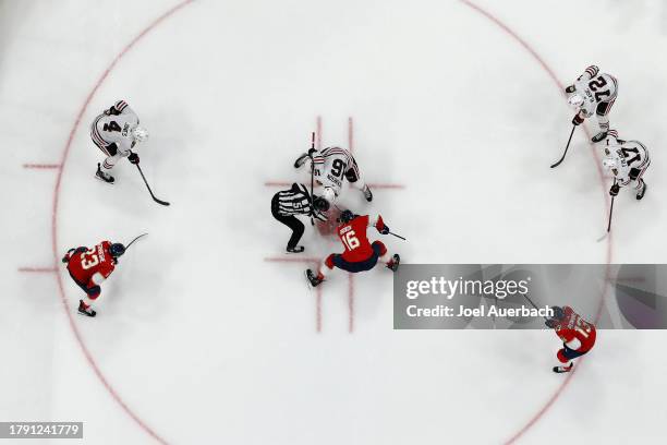 Linesman Andrew Smith drops the puck between Jason Dickinson of the Chicago Blackhawks and Aleksander Barkov of the Florida Panthers at the Amerant...