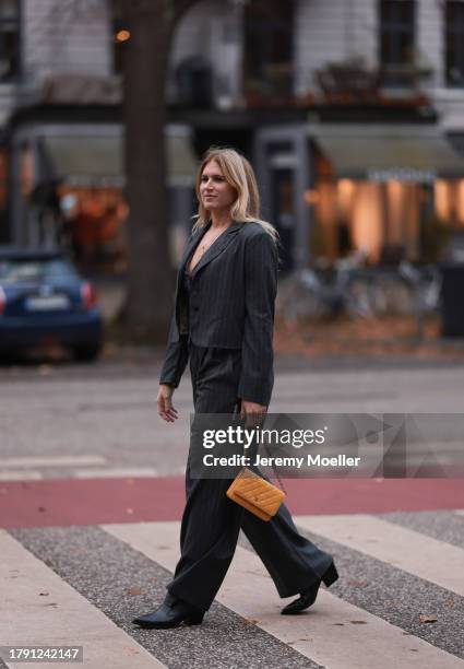 Britta Becker seen wearing gold necklaces, TWELVE by Britta Becker dark grey striped suit vest, matching TWELVE by Britta Becker dark grey striped...