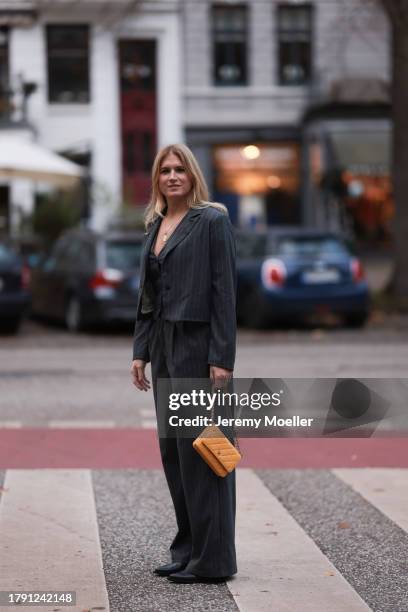 Britta Becker seen wearing gold necklaces, TWELVE by Britta Becker dark grey striped suit vest, matching TWELVE by Britta Becker dark grey striped...