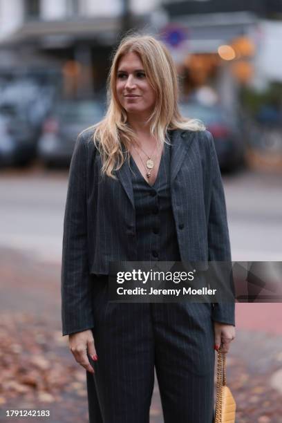 Britta Becker seen wearing gold necklace, TWELVE by Britta Becker dark grey striped suit vest, matching TWELVE by Britta Becker dark grey striped...