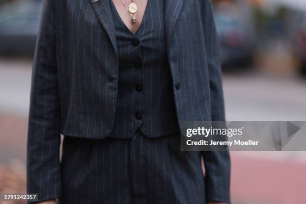 Britta Becker seen wearing gold necklace, TWELVE by Britta Becker dark grey striped suit vest, matching TWELVE by Britta Becker dark grey striped...