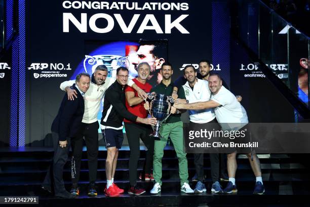 Novak Djokovic of Serbia poses for a photo with the ATP Year End World Number One Trophy and their team and coaches on day two of the Nitto ATP...