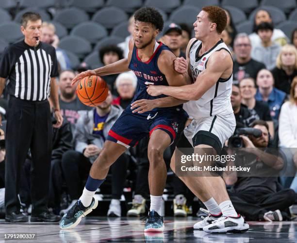 Joshua Jefferson of the St. Mary's Gaels dribbles against Elijah Saunders of the San Diego State Aztecs in the Continental Tire Main Event at...
