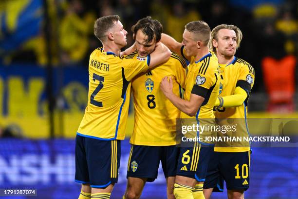 Sweden's midfielder Albin Ekdal is embraced by his teammate as he leaves the pitch for the last time playing for the Swedish National team during the...