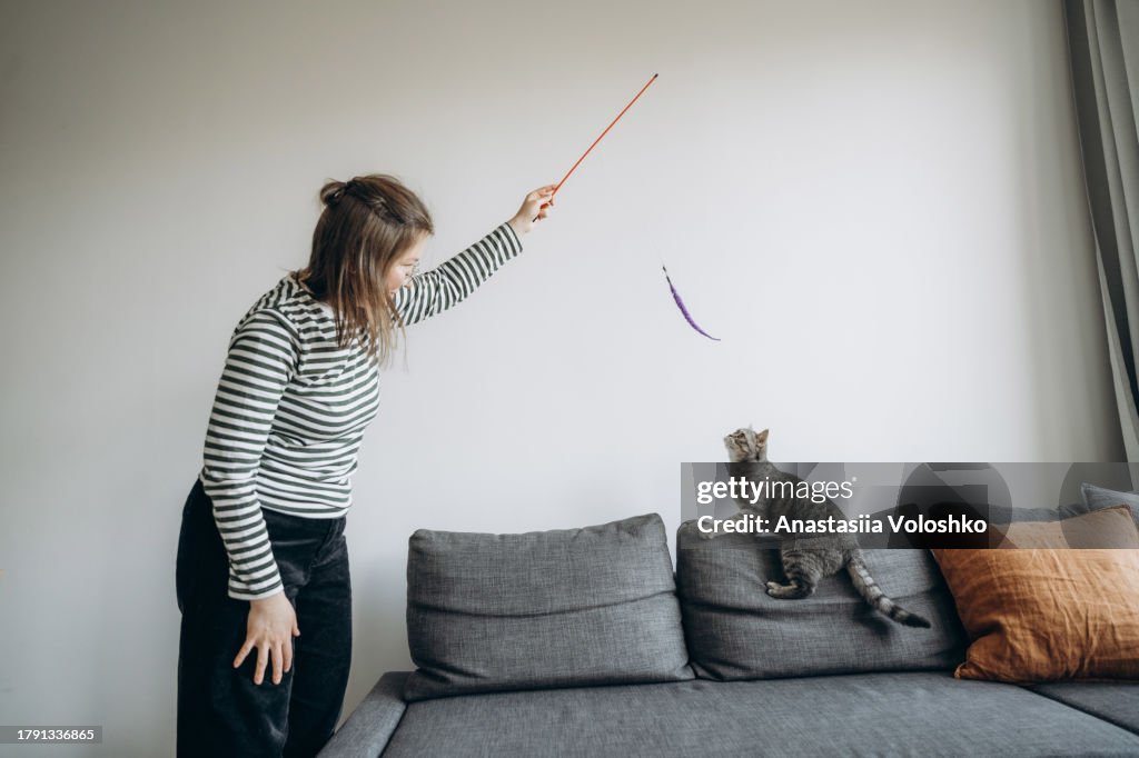 Young woman plays with her domestic cat