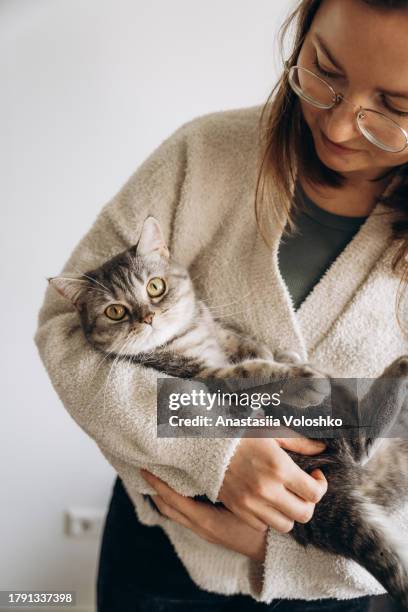 young woman holding a fluffy purring cat in her arms - black and white instant print stock pictures, royalty-free photos & images