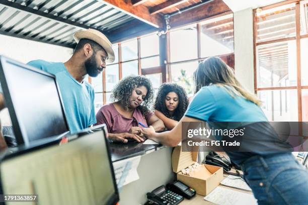 family checking in at hotel reception - terms and conditions stock pictures, royalty-free photos & images