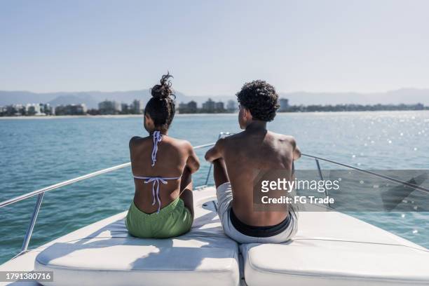 siblings looking at view on a speedboat ride - motorboot varen stockfoto's en -beelden