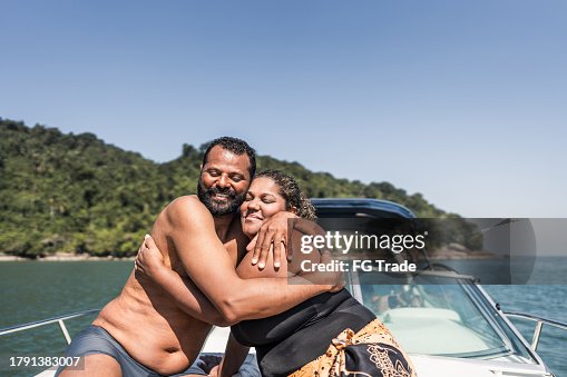Mature couple embracing on a speedboat ride Mature couple embracing on a speedboat ride