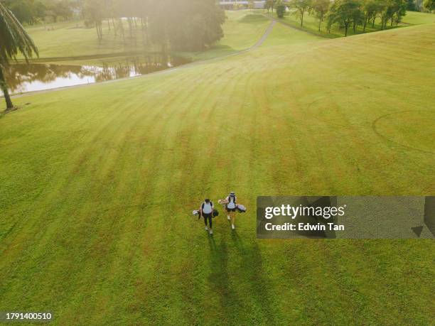 2 golfistas chinos asiáticos caminando en la calle en el campo de golf - golf fotografías e imágenes de stock