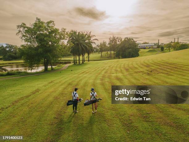2 asian chinese golfers walking in fairway in golf course - long shadow shadow stock pictures, royalty-free photos & images
