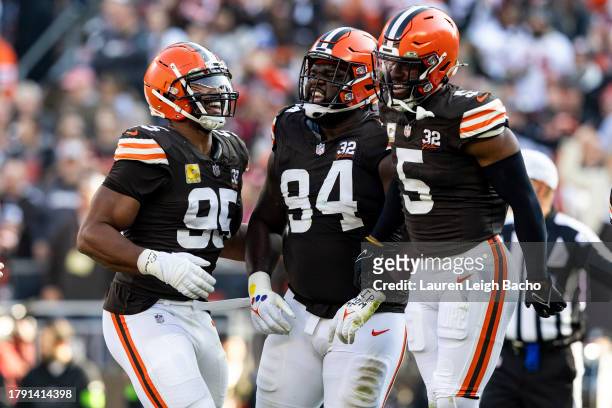 Dalvin Tomlinson of the Cleveland Browns celebrates with Myles Garrett and Anthony Walker Jr. #5 after sacking Clayton Tune of the Arizona Cardinals...