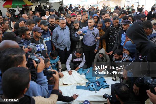 Journalists, relatives and friends pray over the body Journalists Sari Mansour and Hassouna Esleem after they were killed When a house was hit in the...