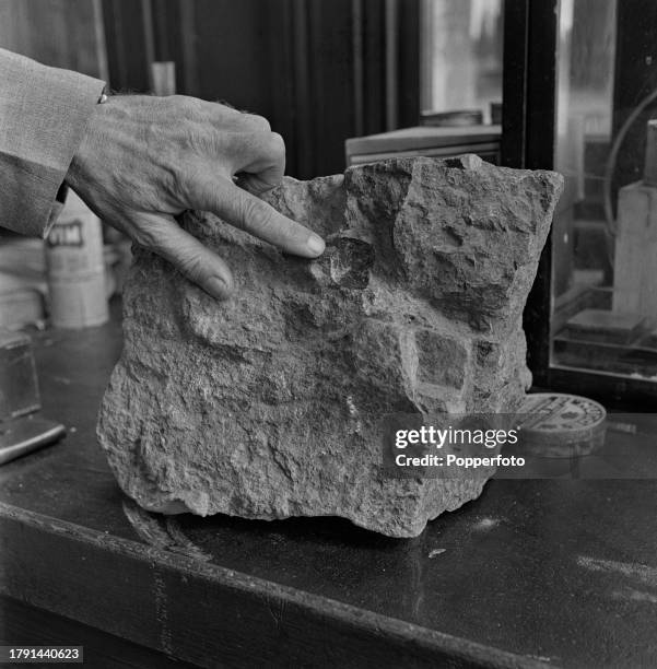 Man points his finger to a diamond embedded in a sample of Kimberlite, a form of diamond bearing igneous rock, in a grading room at the Dutoitspan...