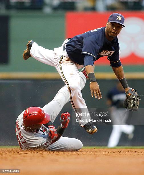 Jean Segura of the Milwaukee Brewers makes the double play over Luis Jimenez of the Los Angeles Angels of Anaheim at second base during third inning...