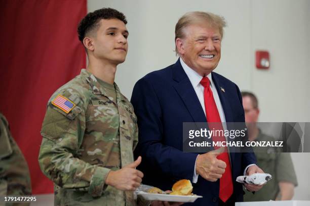 Former US president Donald Trump poses for a photo with a service member at the South Texas International airport on November 19, 2023 in Edinburg,...
