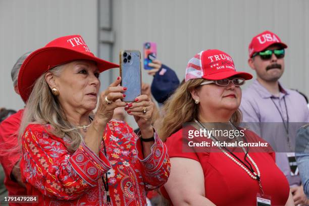 Supporters of former President Donald Trump wear his campaign hats while he gives remarks at the South Texas International airport on November 19,...