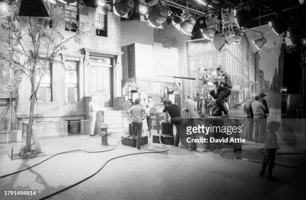 Actor Matt Robinson with Muppet Oscar the Grouch and a young girl, as crew members look on, during the taping of Sesame Street's very first season,...