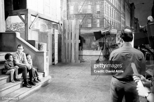 Actor and singer Bob McGrath sits with two children, as crew members look on, during the taping of Sesame Street's very first season, taken for...