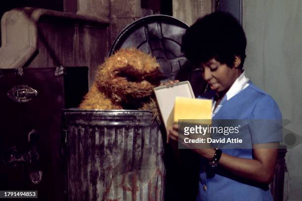 Muppet Oscar the Grouch and actress Loretta Long as the character Susan Robinson during the taping of Sesame Street's very first season, taken for...
