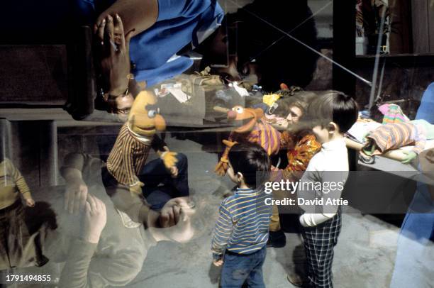 Photo montage of puppeteer Jim Henson , holding Ernie, and puppeteer Frank Oz , holding Bert, entertaining children, superimposed over actress...