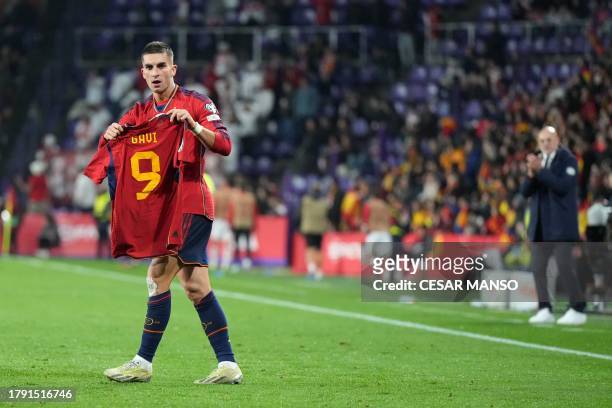 Spain's midfielder Ferran Torres holds the jersey of teammate Spain's midfielder Gavi as he celebrates scoring his team's second goal during the UEFA...
