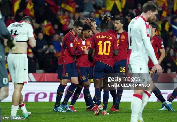 Georgia's defender Luka Lochoshvili reacts to scoring an owngoal as Spain's players celebrate it during the UEFA Euro 2024 group A qualifying...