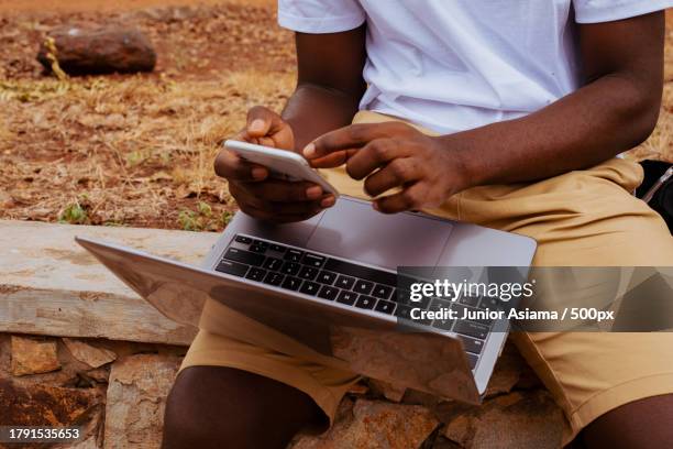 portrait of black student on campus learning with laptop and mobile phone technology,tema,ghana - ghana phone stock pictures, royalty-free photos & images