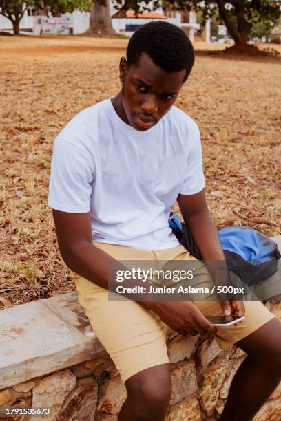 portrait of black student on campus learning with mobile phone technology,tema,ghana - ghana phone stock pictures, royalty-free photos & images