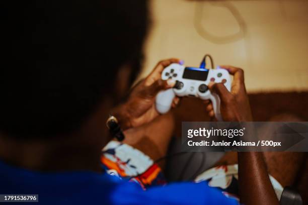 young man playing video game on controller at home,focused - playstation stock pictures, royalty-free photos & images