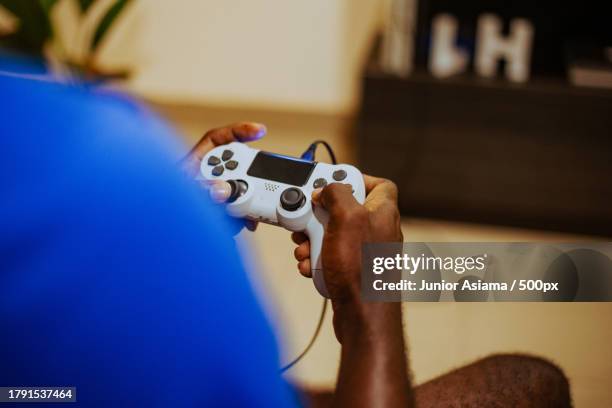 young man playing video game on controller at home,focused - controller di videogame foto e immagini stock