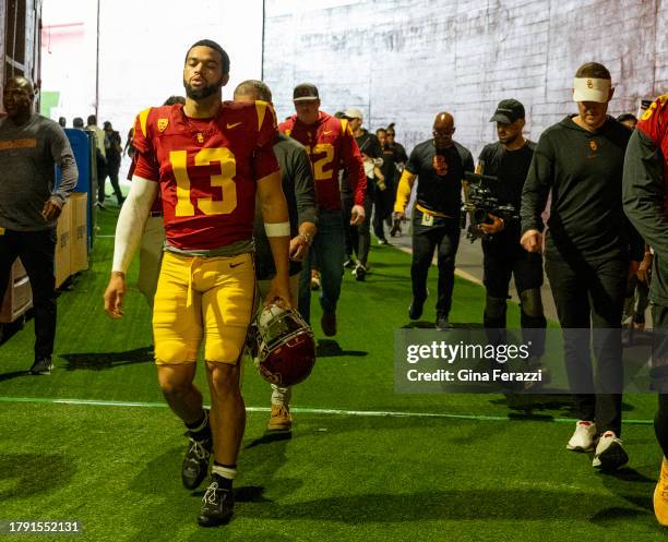 Trojans quarterback Caleb Williams walks through the tunnel to the field with head coach Lincoln Riley on the right before the game against UCLA at...