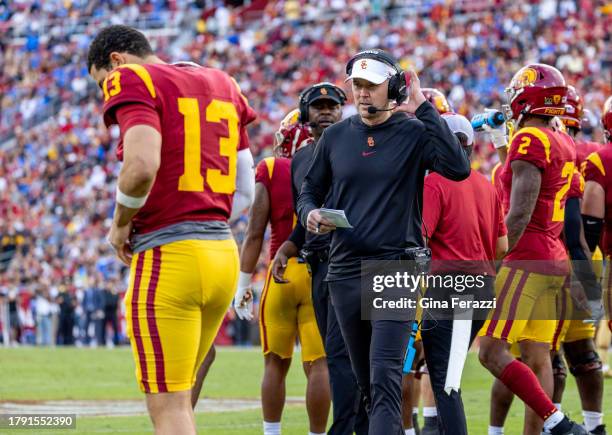 Trojans head coach Lincoln Riley emerges from the huddle during a timeout to speak with USC Trojans quarterback Caleb Williams in the first half of...