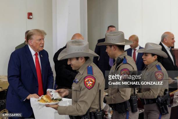 Former US president Donald Trump serves meals to Texas Department of Public Safety troopers at the South Texas International airport on November 19,...