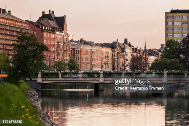 a city skyline by a canal at dusk. - malmo sweden stock pictures, royalty-free photos & images