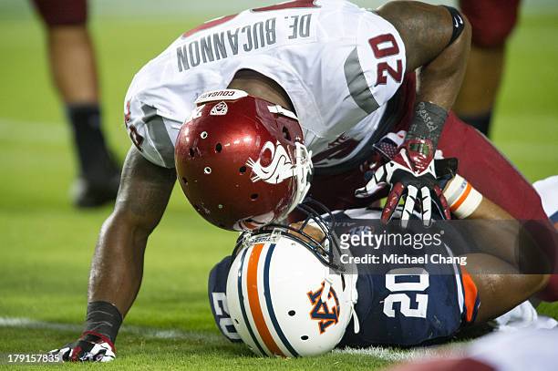 Safety Deone Bucannon of the Washington State Cougars lies on running back Corey Grant of the Auburn Tigers after tackling him during the second half...