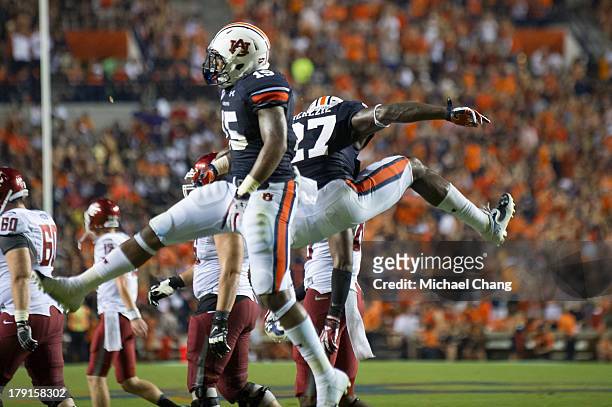 Defensive back Robenson Therezie and defensive back Joshua Holsey of the Auburn Tigers celebrate after an interception during the second half of play...