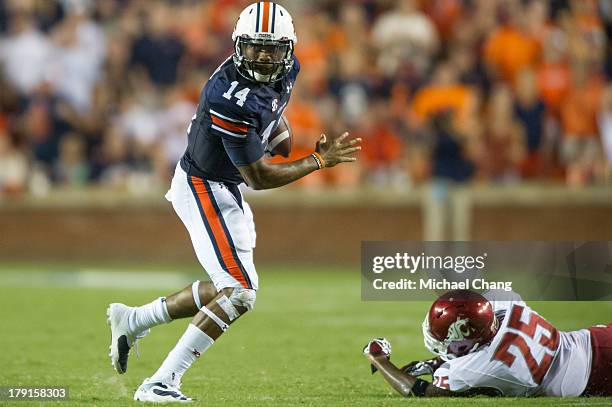 Quarterback Nick Marshall of the Auburn Tigers looks downfield after dodging a tackle from corner back Daquawn Brown of the Washington State Cougars...